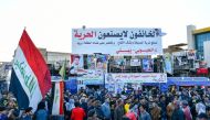 Iraq's wave the national flag during a gathering, rejecting the nomination of Mohammad Allawi as premier, in the city of Nasiriyah in Iraq's southern Dhi Qar province on February 2, 2020. AFP 