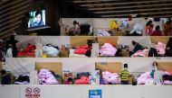 This photo taken on February 18, 2020 shows patients with mild symptoms of the COVID-19 coronavirus resting at night in the temporary Fangcai Hospital set up in a sports stadium in Wuhan, in China's central Hubei province. / AFP / STR
