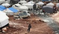 A Syrian boy plays with a football at a makeshift camp for displaced people who fled pro-regime forces attacks in the Idlib and Aleppo provinces, on February 18, 2020. (AFP / Bakr Alkasem)