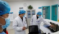 Doctors look at a screen that shows the ward where patients who are infected with the coronavirus are treated at the First People's Hospital in Yueyang, Hunan Province, near the border to Hubei Province, which is under partial lockdown after an outbreak o