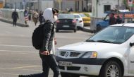 A young Iranian man wearing a protective mask, crosses a busy street in the capital Tehran on February 22, 2020.  AFP / ATTA KENARE