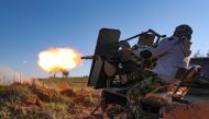 A Turkey-backed Syrian fighter fires a truck-mounted gun toward the town of Saraqeb from the outskits of the villages of Afis and Salihiyah situated near the regime-controlled town, in the eastern part of the Idlib province in northwestern Syria, on Febru
