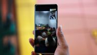 A police officer holds a phone where the gunman and hostage-taker of at least a dozen is on a video call inside a mall in San Juan City, Metro Manila, Philippines, March 2, 2020. REUTERS/Eloisa Lopez