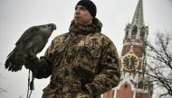 A falconer of the Kremlin ornithological service holds Alpha, a 20-year-old female goshawk, while patrolling in Moscow on March 21, 2019. AFP / Alexander Nemenov