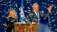 Israeli Prime Minister Benjamin Netanyahu and his wife Sara address supporters as confetti falls upon them at the Likud party campaign headquarters in the coastal city of Tel Aviv early on March 3, 2020, after polls officially closed. AFP / Gil Cohen-Mage