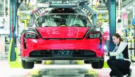 An employee of German luxury car maker Porsche AG works on a Porsche Taycan, Porsche's first all-electric powered car, on the assembly line in the company's plant in Stuttgart, southwestern Germany, on March 4, 2020. AFP / Thomas Kienzle