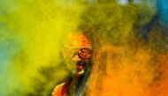 A reveller smeared in colour powder celebrates the Holi, the spring festival of colours, in Mumbai on March 10, 2020. / AFP / Indranil MUKHERJEE
