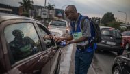 Tshepo Mabasa, 33, walks among cars selling hand sanitizers for 20 rand (1,10 euros) in Johannesburg, on March 11, 2020, amid the outbreak of COVID-19, the new coronavirus. South Africa has registered 13 cases of the new coronavirus. / AFP / Guillem Sarto