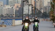 Police members wear face masks as they ride on motorbikes at Beirut's seaside Corniche as Lebanon declared a medical state of emergency on Sunday as part of the preventive measures against the spread of the coronavirus, in Beirut, Lebanon March 15, 2020. 