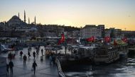 People walk past a nearly empty square at Eminonu as the nation tries to contain the novel coronavirus, COVID-19, in Istanbul on March 17,2020 . / AFP / Ozan KOSE