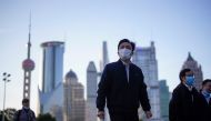 FFILE PHOTO: People wear protective face masks, following an outbreak of the novel coronavirus disease (COVID-19), at Lujiazui financial district in Shanghai, China March 19, 2020. REUTERS/Aly Song - RC22NF9MD3D3/File Photo/File Photo
