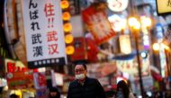 A man, wearing protective mask following an outbreak of the coronavirus disease (COVID-19), walks on an almost empty street in the Dotonbori entertainment district of Osaka, Japan, March 14, 2020. Pictured taken March 14, 2020. REUTERS/Edgard Garrido