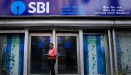 FILE PHOTO: A man checks his mobile phones in front of State Bank of India (SBI) branch in Kolkata, India, February 9, 2018. REUTERS/Rupak De Chowdhuri/File Photo