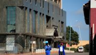 Men wear protective masks as they walk down a deserted street on the first day of the 21-day nationwide lockdown aimed at limiting the spread of coronavirus disease (COVID-19) in Harare, Zimbabwe, March 30, 2020. REUTERS/Philimon Bulawayo
