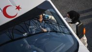 A Turkish health official checks the temperature of a driver at a check point, on the Asian side ,entry of Istanbul on March 30,2020. President Recep Tayyip Erdogan called on Turks to stay at home and adapt themselves to 