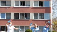 Careworkers of a nursing home enjoy as the MAV Symphony Orchestra plays classical music recordings on loudspeakers of a car going around the city to cheer up people under lockdown, during the coronavirus disease (COVID-19) outbreak in Budapest, Hungary, A