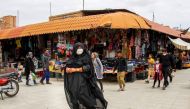 Iranians, some wearing personal protective equipment, walk past shops in the southeastern city of Kerman on April 11, 2020, amid the coronavirus (COVID-19) pandemic. AFP / ISNA
