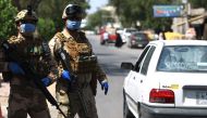 Iraqi soldiers stand at a checkpoint in the Adhamiya district of Baghdad on April 13, 2020 as Iraq imposed a curfew during the coronavirus COVID-19 pandemic. / AFP / AHMAD AL-RUBAYE