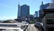 Cyclists (C) make their way through streets made empty by the lockdown restrictions in place due to the COVID-19 coronavirus outbreak in central Sydney on April 15, 2020. / AFP / Saeed KHAN