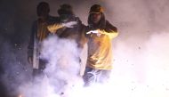 :Devotees, one of them wearing a face mask, walk through the fire crackers to celebrate Mazu's birthday in front of Chaotian Temple in Beigang, amid the spread of the coronavirus disease (COVID-19) in Yunlin, Taiwan on April 15, 2020. REUTERS/Ann Wang