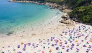 This aerial photo shows people gathering at a beach in Hong Kong on April 19, 2020. Starting on March 29 the city's government banned public gatherings of more than four people in an effort to curb the spread of the COVID-19 coronavirus. / AFP / Dale DE L