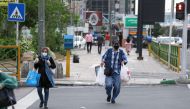 Iranians wearing protective masks amid the COVID-19 pandemic, cross a street in the capital Tehran, on April 26, 2020. / AFP / ATTA KENARE