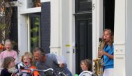 A member of the Royal Concertgebouw Orchestra plays the Dutch Wilhelmus anthem to celebrate King's Day (Koningsdag), as she stands on the doorway, during the coronavirus disease (COVID-19) outbreak in Amsterdam, Netherlands, April 27, 2020. REUTERS/Eva Pl