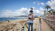 A father carries his son on his shoulders at Can Pere Antoni Beach in Palma de Mallorca, on April 26, 2020 during a national lockdown to prevent the spread of the COVID-19 disease. / AFP / JAIME REINA