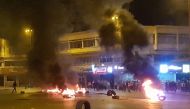 Lebanese anti-government protesters burn tyres amid clashes with security forces in the northern city of Tripoli late on April 27, 2020, following a demonstration over the country's deteriorating economy despite a coronavirus lockdown. Lebanon is facing i