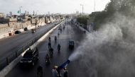 Volunteers spray disinfectant from a vehicle while sanitising a residential area along a road amid the outbreak of the coronavirus disease (COVID-19) in Karachi, Pakistan May 4, 2020. REUTERS/Akhtar Soomro
