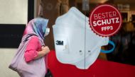 A woman walks past a store selling face masks and hygienic supplies in Vienna, Austria on May 4, 2020, amidst the new coronavirus COVID-19 pandemic. From May 1, stores were reopened in Austria and people have been allowed to leave their homes with fewer r