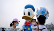 Visitors wearing face masks are seen at Shanghai Disney Resort a day before the Shanghai Disneyland theme park reopens following a shutdown due to the coronavirus disease (COVID-19) outbreak, in Shanghai, China May 10, 2020. REUTERS/Aly Song