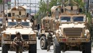 A foreign soldier keeps watch among armoured vehicles outside a hospital which came under attack in Kabul, Afghanistan May 12, 2020. REUTERS/Mohammad Ismail
