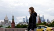 A woman wearing a mask as a precaution against coronavirus walks at a street in Moscow, Russia on May 19, 2020.  Sefa Karacan - Anadolu 
