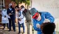 Doctors Without Borders (MSF) nurse Bhelekazi Mdlalose (2nd R), 51, performs a swab test for COVID-19 coronavirus on a health worker at the Vlakfontein Clinic in Lenasia, Johannesburg, on May 13, 2020./ AFP / Michele Spatari
