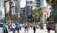 Residents of the Lebanese capital Beirut stroll along the seaside corniche, despite the lingering threat of the novel coronavirus, on May 31, 2020. / AFP / ANWAR AMRO