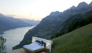 Dominic Gregorin and Anja Wachter (L) pose in the bedroom of the Zero-Real-Estate land art installation by Swiss artists Frank and Patrik Riklin, as the outbreak of the coronavirus disease (COVID-19) continues, on an alp in front of the Churfirsten mounta
