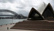 FILE PHOTO: People are seen on the nearly deserted steps of the Sydney Opera House, in the wake of New South Wales implementing measures shutting down non-essential businesses and moving toward harsh penalties to enforce self-isolation as the spread of co