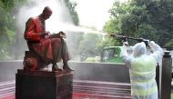A municipal employee cleans a statue of a famous Italian journalist Indro Montanelli on June 14, 2020 in a Milan public square, a day after it was defaced and stained with red paint. AFP / MIGUEL MEDINA