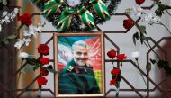 FILE PHOTO: Flowers lie around a portrait of Iranian Major-General Qassem Soleimani, who was killed in an airstrike near Baghdad, at the Iranian embassy's fence in Minsk, Belarus January 10, 2020. REUTERS/Vasily Fedosenko/File Photo