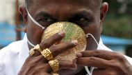 Shankar Kurhade (48), wears his face mask made out of gold as he poses for a photograph amidst the spread of the coronavirus disease (COVID-19) in Pune, India, July 4, 2020. REUTERS/Stringer 