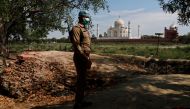 A policeman wearing a protective mask stands guard near the historic Taj Mahal during a nationwide lockdown to slow the spread of COVID-19, in Agra, India, April 23, 2020. Picture taken April 23, 2020. REUTERS/Adnan Abidi/File Photo
