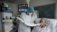 Christian George, Director of Research at the National Centre of Scientific Research, helps a patient suffering from coronavirus disease (COVID-19) to use the COVID-19 'Breathalyzer' test machine at the La Croix-Rousse Hospital in Lyon, France, July 22, 2