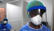 A healthcare worker wearing protective gear stands next to a testing booth for the coronavirus disease (COVID-19) at an Institute for Health Research, Epidemiological Surveillance and Training (IRESSEF) testing center, in Dakar, Senegal July 24, 2020. REU