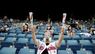 A fan wearing a face mask as a measure to avoid the spread of the coronavirus disease (COVID-19) cheers during a KBO baseball game between LG Twins and Doosan Bears at a baseball stadium in Seoul, South Korea, July 26, 2020. REUTERS/Heo Ran