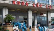 Vietnamese construction workers in blue protective suits, infected with the coronavirus disease (COVID-19), arrive at the tropical diseases hospital after being repatriated from Equatorial Guinea via a specially-adapted Vietnam Airlines plane filled with 