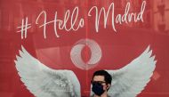 A man wearing a face mask stands outside a shop in Madrid on July 29, 2020. Madrid moved to make mask-wearing obligatory at all times in public as Spain grappled with the fallout from a spike in virus cases that has triggered several international travel 