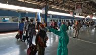 A worker wearing protective gear checks the temperature of a traveller at Dadar railway station, amidst the spread of the COVID-19 in Mumbai, India, July 31, 2020. (REUTERS/Hemanshi Kamani)