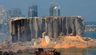 TOPSHOT - A picture taken on August 5, 2020 shows the damaged grain silo and a burnt boat at Beirut's harbour, one day after a powerful twin explosion tore through Lebanon's capital, resulting from the ignition of a huge depot of ammonium nitrate at the c