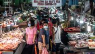 People wearing masks shop for fresh food at a market in Manila on August 6, 2020.  AFP / Lisa Marie David

